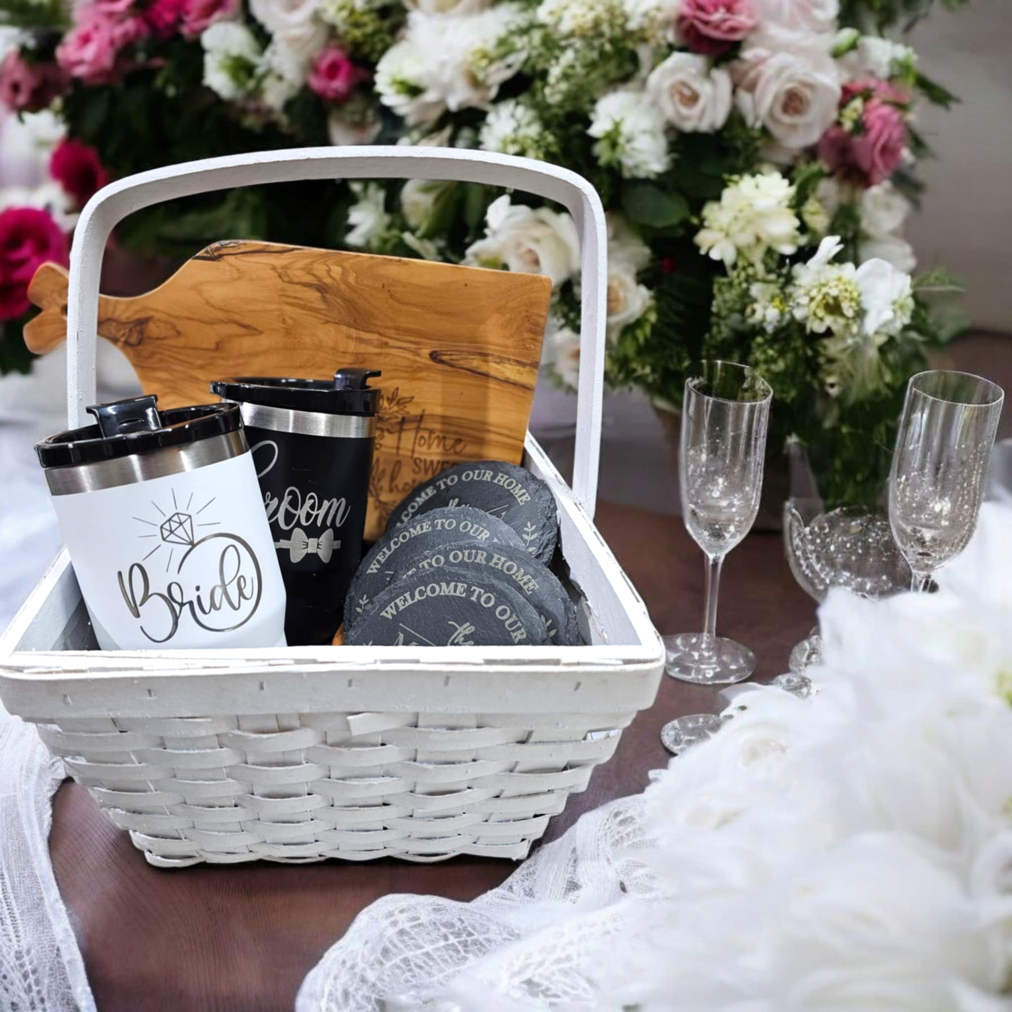 Bride & Groom laser engraved tumblers in a wedding gift basket with engraved coasters and a cutting board.