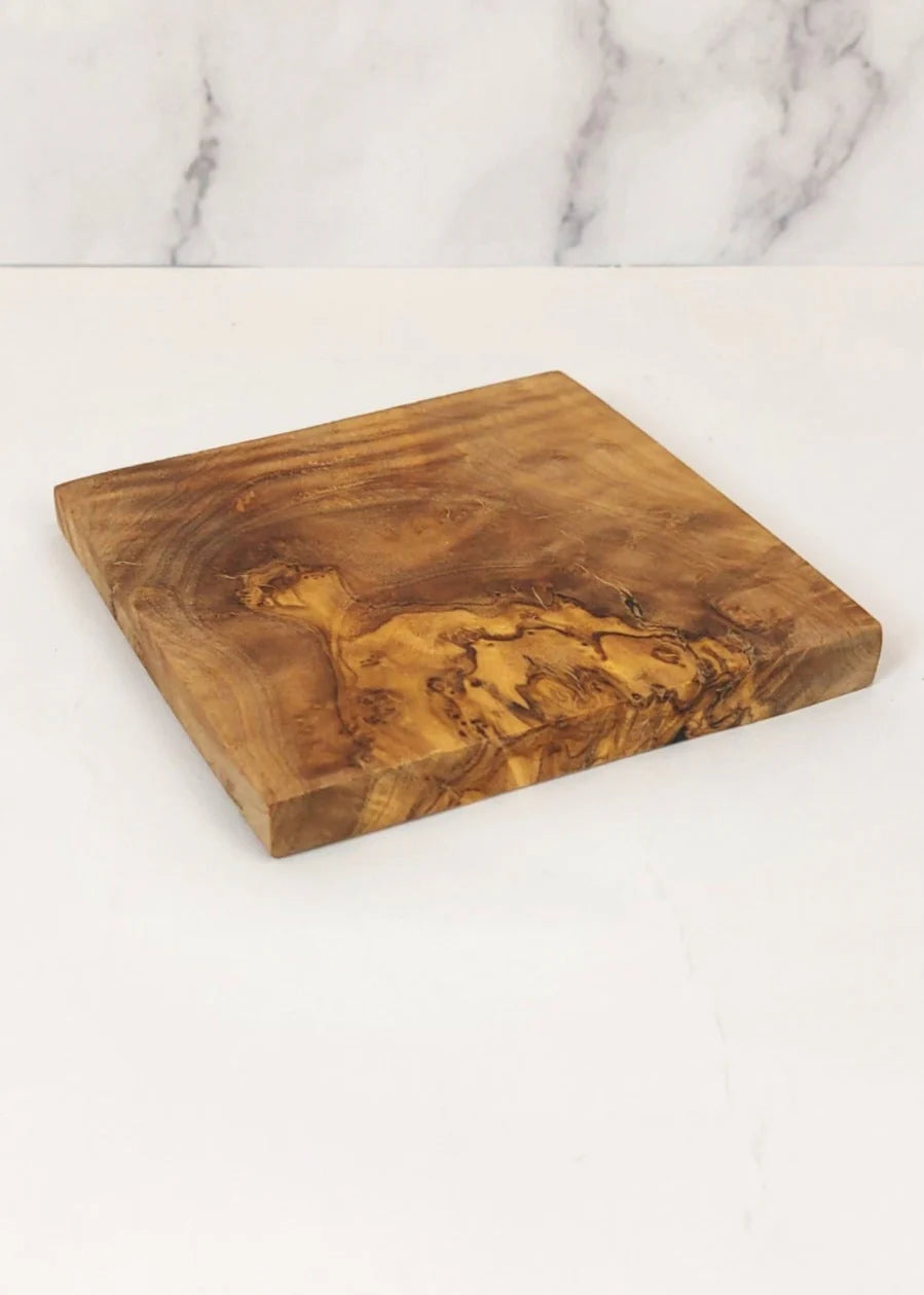 Square olive wood coaster on a marble surface