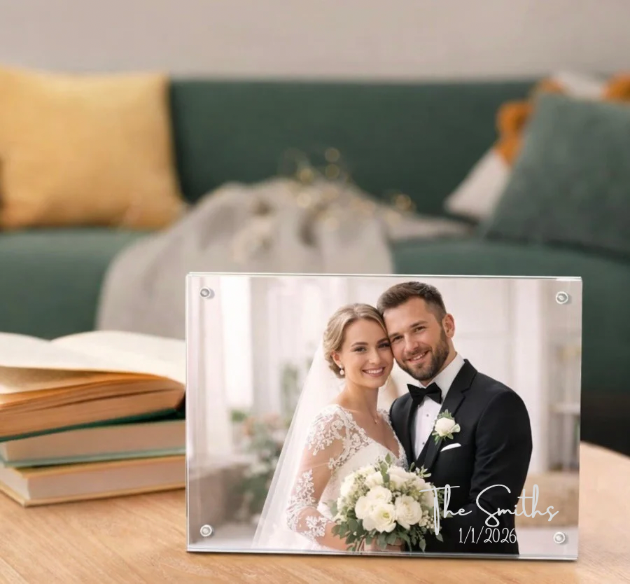 Clear acrylic photo frame held together with magnets, with a picture of a bride & groom, that is laser engraved with their last name and wedding date.